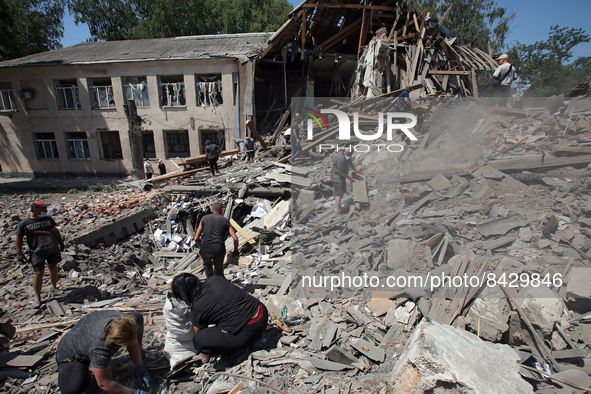 LIUBOTYN, UKRAINE - JUNE 20, 2022 - People remove the rubble at the Liubotyn Railway Transport Lyceum which hosted a humanitarian aid wareho...