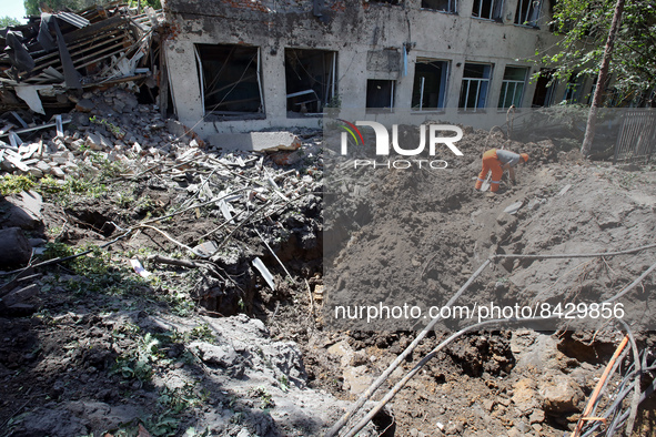 LIUBOTYN, UKRAINE - JUNE 20, 2022 - A man removes the rubble at the Liubotyn Railway Transport Lyceum which hosted a humanitarian aid wareho...