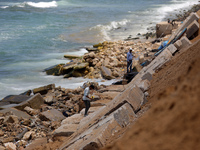 Palestinian construction workers build a seawall, from the rubble of building, to counter the coastal erosion near the al-Shati camp for Pal...