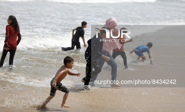 Palestinian children enjoy in the Mediterranean sea in Gaza City on June 22, 2022. 