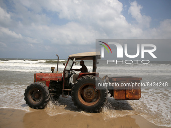 A Palestinian man drives a tractor on the shore of the Mediterranean Sea in Gaza City, June 22, 2022. (