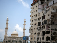 workers remove rubble of a building destroyed by an Israeli air strike during the May 2021 conflict between Israel and Hamas in Gaza City, o...