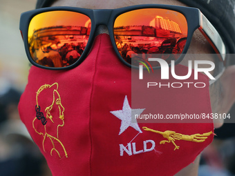 A protester wears a facemask of the National League for Democracy (NLD) party as he takes part in a demonstration against the military coup...