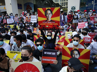 (FILE PHOTO) Myanmar protesters hold up placards with pictures of Aung San Suu Kyi during a demonstration against the military coup near Sul...