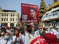 (FILE PHOTO) A protester holds a placard with a picture of Aung San Suu Kyi during a demonstration against the military coup near Sule Pagod...
