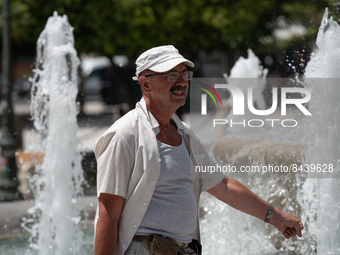 A man tries to cool off at a fountain at Syntagma Square during a heatwave in Athens, Greece, on June 23, 2022 (