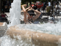 A woman tries to cool off at a fountain at Syntagma Square during a heatwave in Athens, Greece, on June 23, 2022 (