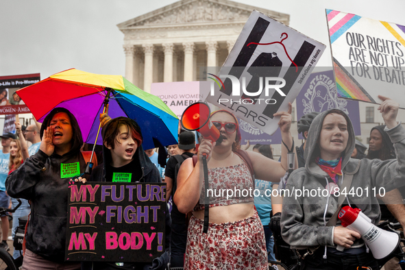Pro-choice (front) and anti-abortion (back) activists demonstrate at the Supreme Court as they await its decision on Dobbs v. JWHO.  A draft...