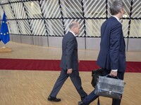 Olaf Scholz Federal Chancellor of Germany arrives at the EU summit, walking next to the European flags, flag of Europe and talks to the medi...