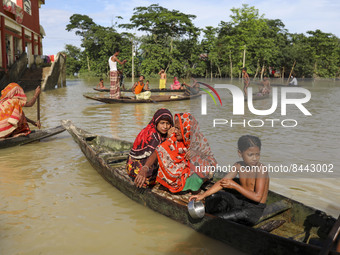 Flood affected women and children seat on a boat to collect relief front of a relief center at Sylhet, Bangladesh on June 24, 2022. (