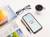 In this photo illustration a Tmall logo seen displayed on a smartphone screen on a desk next to a cafe, a pen, glasses and a magazine in Ath...