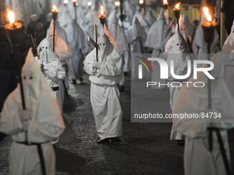 Hooded Penitents of the Arciconfraternita of Saint Monica carry crosses and torches as they take part in Good Friday procession long the str...
