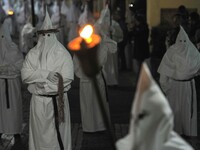 Hooded Penitents of the Arciconfraternita of Saint Monica carry crosses and torches as they take part in Good Friday procession long the str...