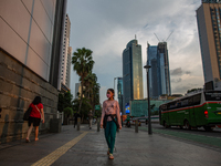 A woman wear protective face masks while walking at pedestrian in Jakarta on 5 July 2022. The Indonesian government on Tuesday, July 5, rais...