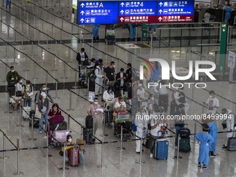Travellers waiting in line for shuttle bus to quarantine hotels inside Hong Kong International Airport on July 7, 2022 in Hong Kong, China....
