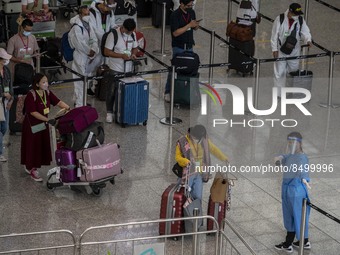 Travellers waiting in line for shuttle bus to quarantine hotels inside Hong Kong International Airport on July 7, 2022 in Hong Kong, China....