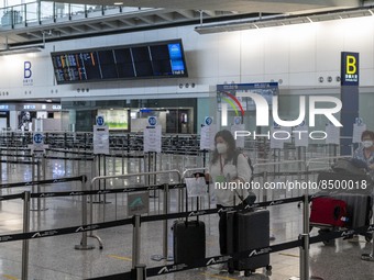 Travellers pushing luggage trolley after arrive in Hong Kong inside Hong Kong International Airport on July 7, 2022 in Hong Kong, China. The...