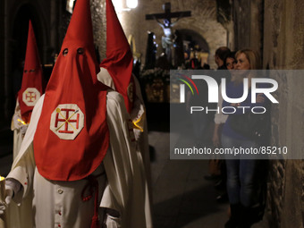 Pedestrians look to penitents that take part in a Holy week  procession called the 