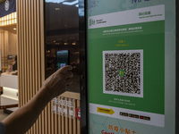 A man scanning the Leave Home Safe QR code with his phone at the entrance of a shopping mall on July 15, 2022 in Hong Kong, China. (