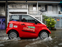 A 7-Eleven electric car makes deliveries during heavy flooding in Bangkok on July 21, 2022. (