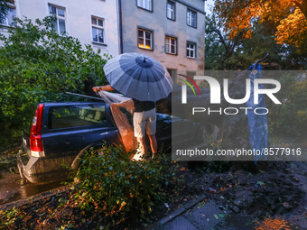 A huge tree was knocked down by a strong wind and rain, falling on a car parked on a street. Krakow, Poland on July 23, 2022. After a few ho...