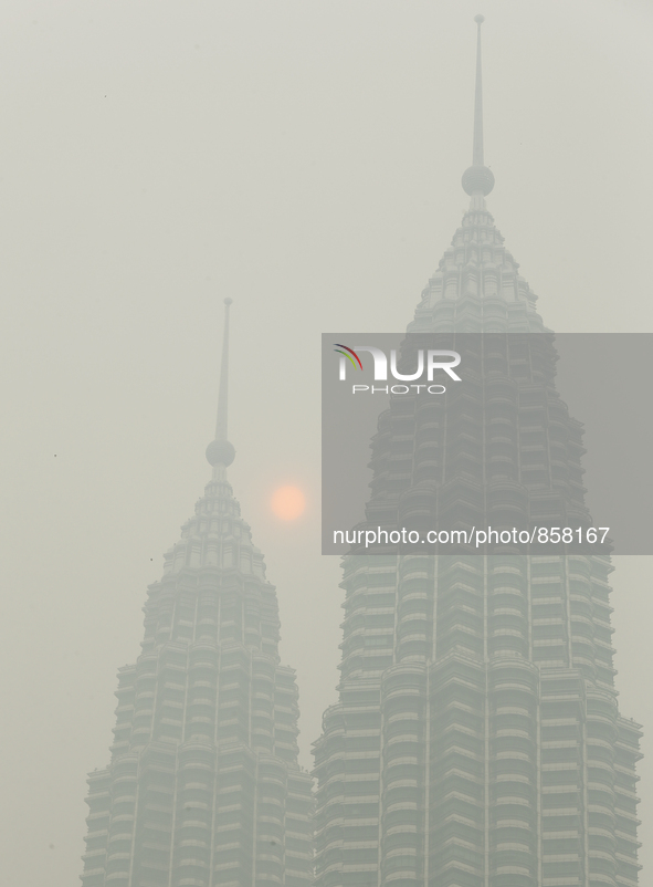 The sun is partly covered by haze near a Malaysia's landmark Petronas Twin Towers in Kuala lumpur on October 20, 2015. Mohd Daud/NurPhoto 