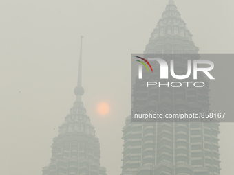 The sun is partly covered by haze near a Malaysia's landmark Petronas Twin Towers in Kuala lumpur on October 20, 2015. Mohd Daud/NurPhoto (