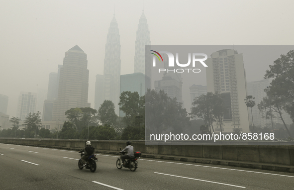 A motorist passes the Kuala Lumpur skyline shrouded by thick haze in Kuala Lumpur, Malaysia on October 20, 2015. Mohd Daud/NurPhoto 