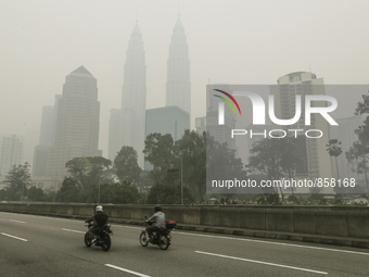 A motorist passes the Kuala Lumpur skyline shrouded by thick haze in Kuala Lumpur, Malaysia on October 20, 2015. Mohd Daud/NurPhoto (