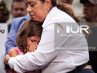 Rosie Lopez-Torres, co-founder and executive director of Burn Pits 360, comforts Brielle Robinson,9, during a press conference condeming Rep...
