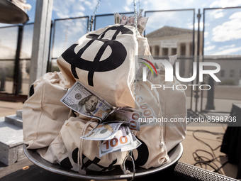 Bags of money weigh down the scales of justice during a petition delivery - signed by more than 1.2 million people - to Congresswoman Ilhan...