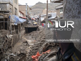 An Iranian policeman looks at an area which is demolished in flash flooding in the flooded village of Imamzadeh Davood in the northwestern p...