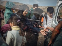 Volunteers hand out water to newly arrived refugees once they get off the boats from the Turkish coast, on September 27, 2015.  (