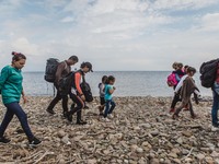 Migrants walk along the beach after they arrive on the Greek island of Lesbos, on September 28, 2015.  (