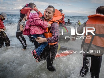 A father carries his daughter off their boat which was stranded in the water for five hours without a motor, in Lesbos, on September 30, 201...