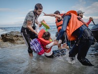 Migrants rush off the dinghy they crossed the sea with once they arrive in Lesbos, Greece, on September 30, 2015.  (
