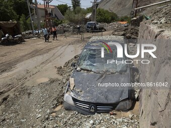 A vehicle stuck in rocks after a flash flooding in the flooded village of Mazdaran in Firoozkooh county 124 km (77 miles) northeast of Tehra...