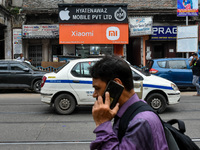 A man talking on phone walks past a Xiaomi store in Kolkata , India , on 5 August 2022 . Indian government tightens oversee over Chinese pho...