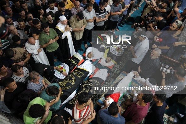 Palestinian mourners carry the bodies of the victims killed earlier in an Israeli air strike, during their funeral in Gaza City, on August 5...