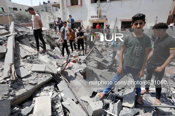 Palestinians inspect the ruins of a collapsed building destroyed by an Israeli air strike in Gaza City, on August 6, 2022. - Israel on Augus...