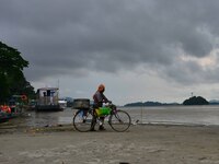 Fish vendor arrives to clean his fish container in the banks Brahmaputra river during a cloudy day, in Guwahati ,India on August 6,2022. (