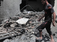 Palestinians inspect the ruins of a collapsed building destroyed by an Israeli air strike in Gaza City, on August 6, 2022. Israel on August...