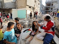 Palestinian children are entertained by clowns amidst the rubble of a building destroyed in the latest round of fighting between Israel and...