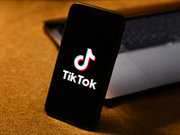 TikTok logo displayed on a phone screen and a laptop are seen in this illustration photo taken in Krakow, Poland on August 10, 2022. (