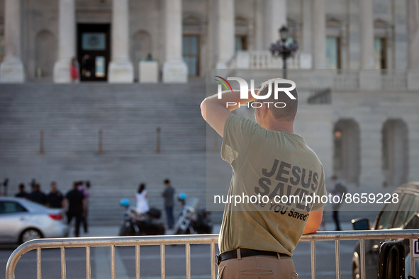 A visitor to the US Capitol watches as Congresspeople exit the House chamber after voting on the Inflation Reduction Act in the House of Rep...