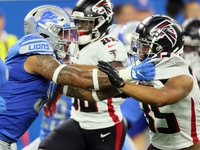 Linebacker Josh Woods (51) of the Detroit Lions cornerback holds the line against Avery Williams (35) of the Atlanta Falcons during an NFL p...