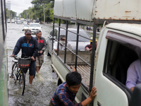 People push a vehicle through a flooded road after heavy rain in Yangon, Myanmar on August 17, 2022. (