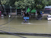 A man rides a bicycle through a flooded road after heavy rain in Yangon, Myanmar on August 17, 2022. (