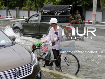 A man pushes his bicycle through a flooded road after heavy rain in Yangon, Myanmar on August 17, 2022.
 (