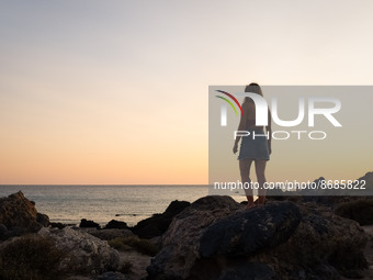 A woman enjoy the sunset at Cedar Forest (Kedrodasos) beach in Chania, Crete Island, Greece on August 18, 2022. (